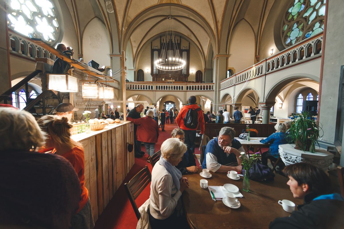 Menschen treffen sich zum Kaffee in einer umgenutzten Kirche